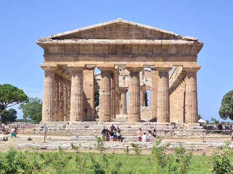The Temple of Athena at Paestum, an ancient Greek temple with well-preserved Doric columns and a clear blue sky.