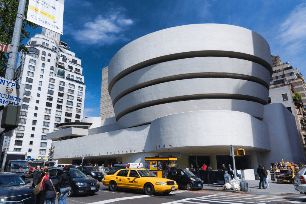 Exterior view of the Guggenheim Museum in New York City, showcasing its distinctive spiraling design and surrounding urban environment.