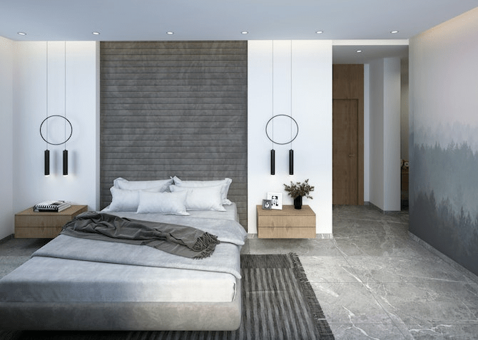 A modern bedroom featuring a large bed with gray bedding, a textured accent wall, two circular pendant lights, wooden nightstands, and a minimalist decor style.
