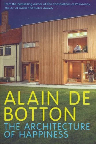 Book cover of 'The Architecture of Happiness' by Alain de Botton, featuring a modern house with wooden cladding, a garden, and a person visible in a window.